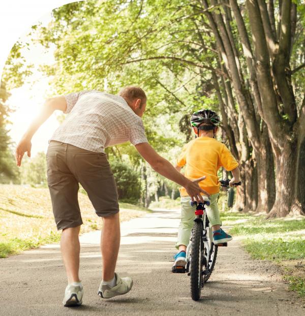 Vader leert kind fietsen